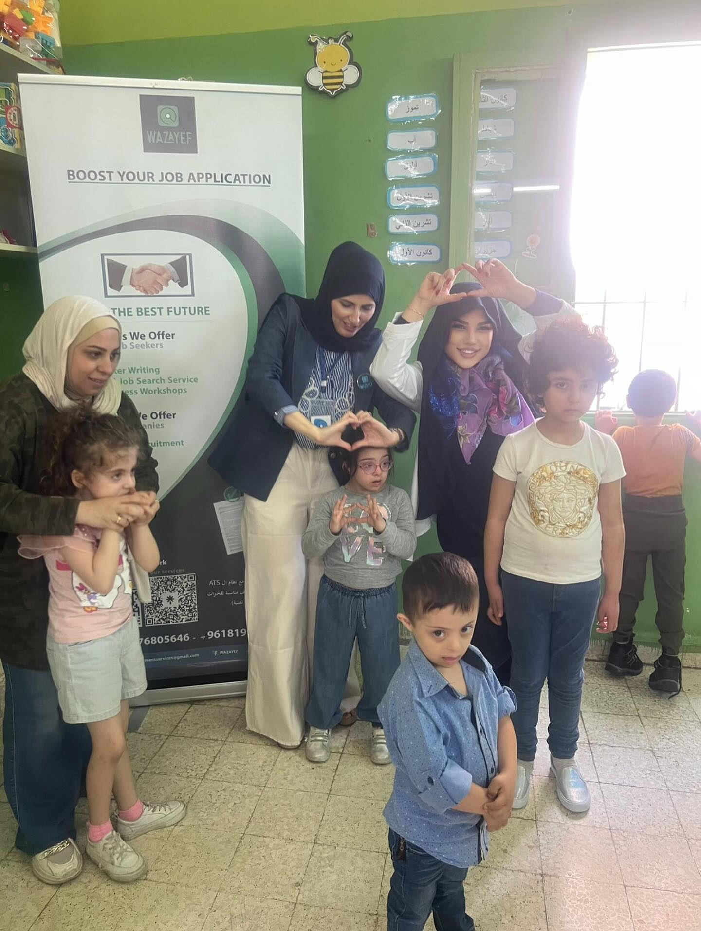 Matensouna Foundation team members and children making heart shapes with their hands, showing community love and support